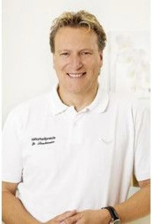 Porträt von Dr. med. Christian Laubender im weißen Praxis-Poloshirt
